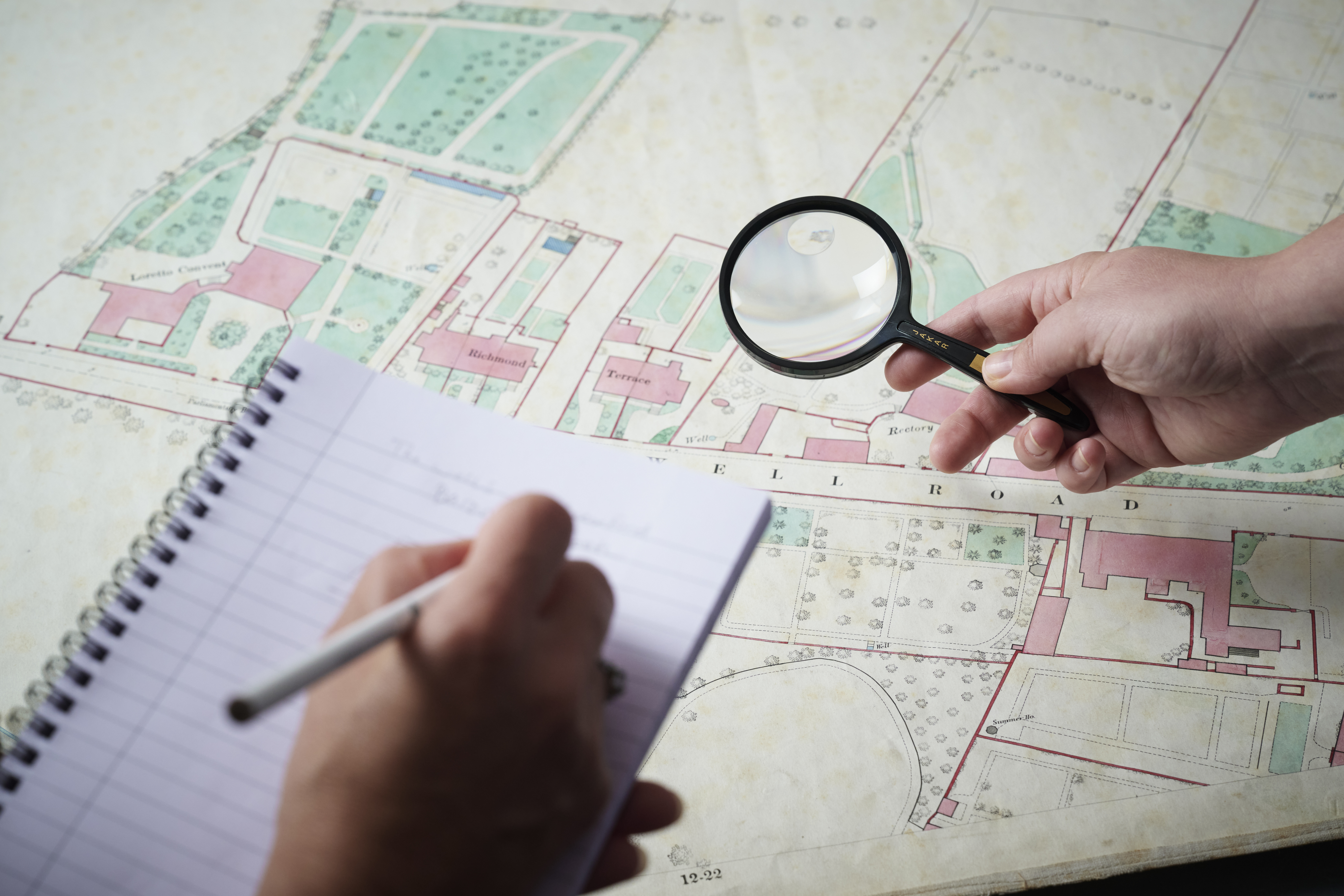 Researchers inspecting a map from the archives and taking notes